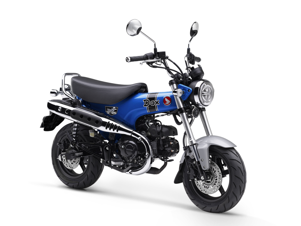 Ein blaues Honda Dax-Minibike mit schwarzem Sitz, silbernem Auspuff, rundem Scheinwerfer und verchromtem Lenker, von der Seite betrachtet auf weißem Hintergrund - perfekt für das HONDA Summer Special. Rider's Point der Kaltenbach Gruppe. Dein Partner für BMW Motorrad und Honda.