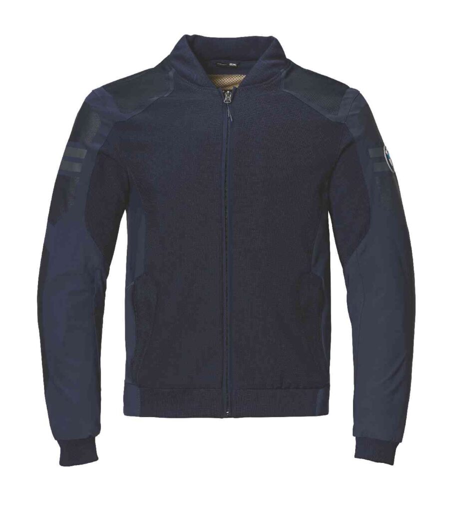 Dunkelblaue Jacke mit Reißverschluss, langen Ärmeln, gerippten Bündchen und einem Stehkragen. Die Jacke hat dezente Schulterdetails und einen BMW Motorrad Fahrerausstattung reduziert Aufnäher auf dem oberen linken Ärmel. Rider's Point der Kaltenbach Gruppe. Dein Partner für BMW Motorrad und Honda.