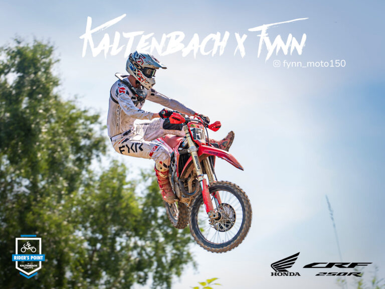 Ein Motocross-Fahrer in weißer Kleidung springt auf einem roten Honda CRF 250R Dirt Bike vor einem blauen Himmel, mit Bäumen im Hintergrund und verschiedenen Motocross-Sponsoring-Logos und Texten, die das Bild überlagern. Rider's Point der Kaltenbach Gruppe. Dein Partner für BMW Motorrad und Honda.