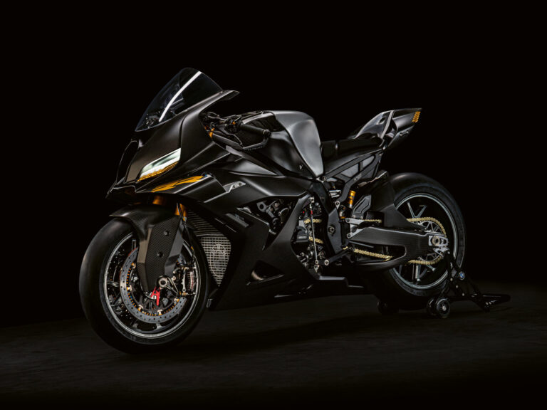 Ein schnittiges, schwarzes Sportmotorrad mit aerodynamischen Verkleidungen, scharfen Linien und gelben Akzenten ist auf einem dunklen Hintergrund abgebildet, der sein modernes, leistungsstarkes Design hervorhebt. Rider's Point der Kaltenbach Gruppe. Dein Partner für BMW Motorrad und Honda.